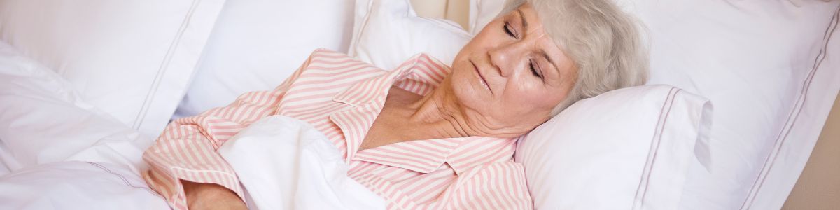 Cuidadora nocturna velando el descanso de una persona mayor en su hogar